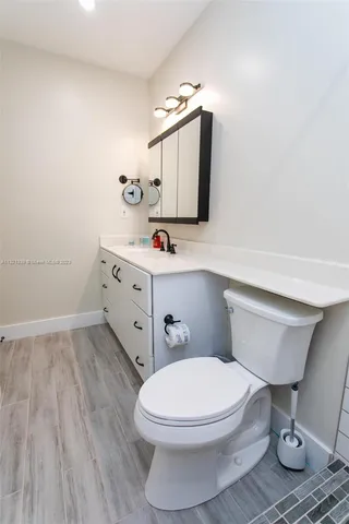 a bathroom with a toilet a sink and mirror