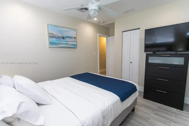 a bedroom with a bed and a flat screen tv