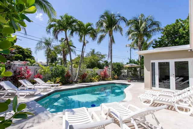 a view of a backyard with potted plants and palm trees