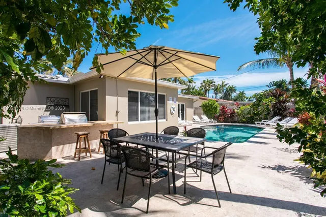 a patio with a table and chairs under an umbrella