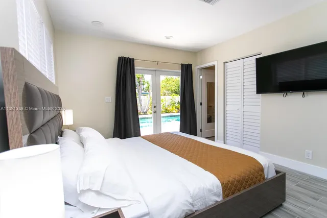 a bedroom with a large bed and a flat screen tv