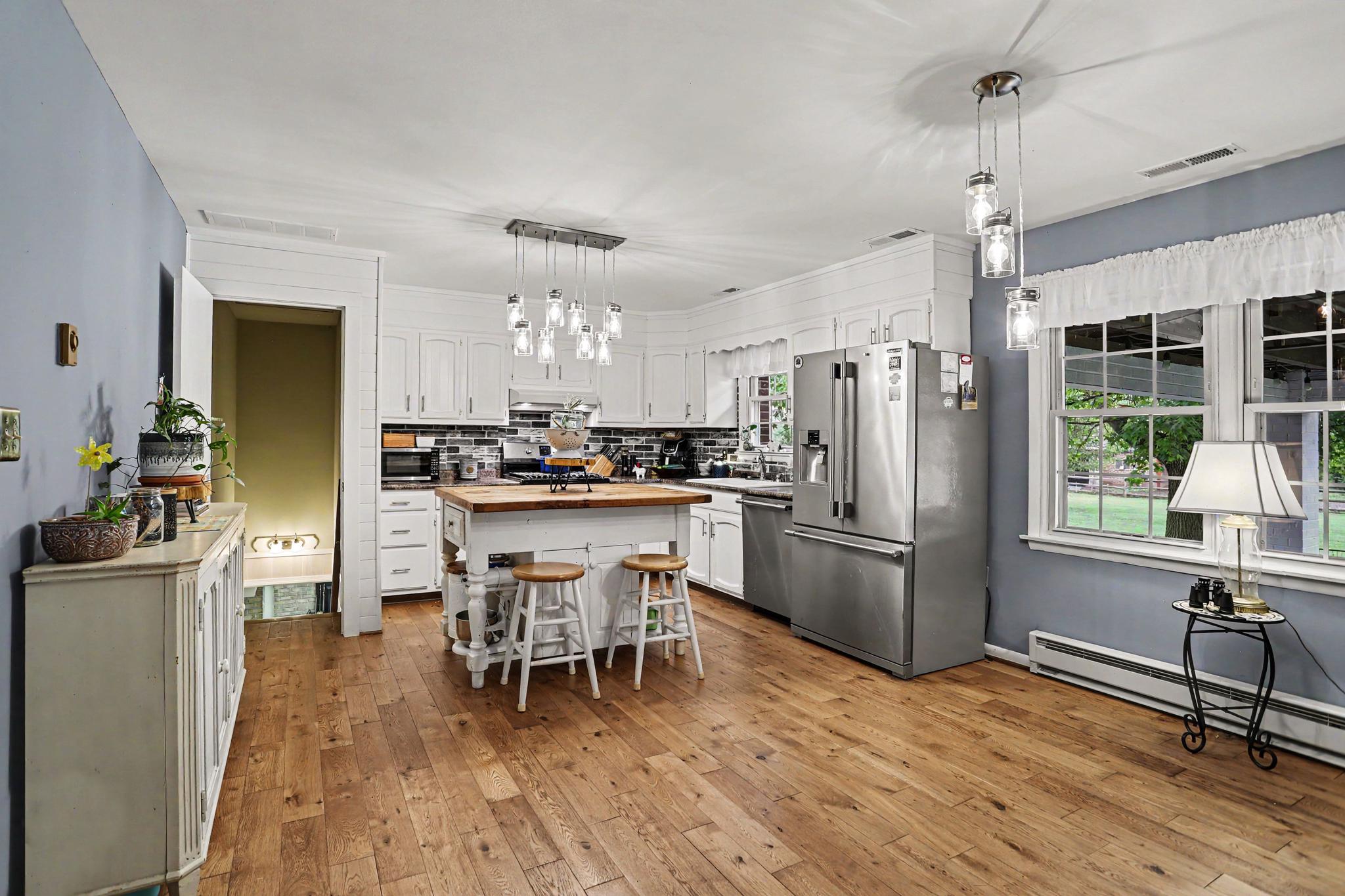 2226 Harney Road Littlestown, PA 17340 - Photo 6 of 40 a kitchen with stainless steel appliances a refrigerator a stove top oven a sink dishwasher and a dining table with wooden floor