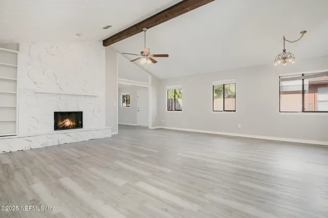 a view of empty room with windows and fireplace
