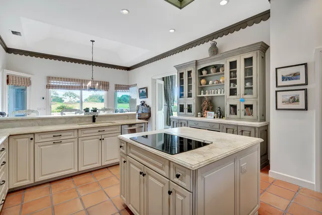 a large white kitchen with a stove a sink dishwasher and a refrigerator with wooden floor
