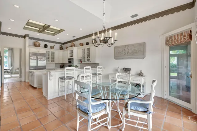 a kitchen with stainless steel appliances a table and chairs in it