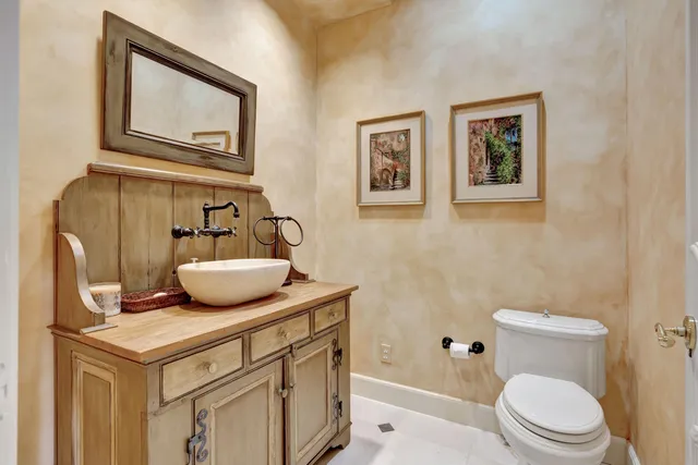 a bathroom with a granite countertop sink a toilet and shower