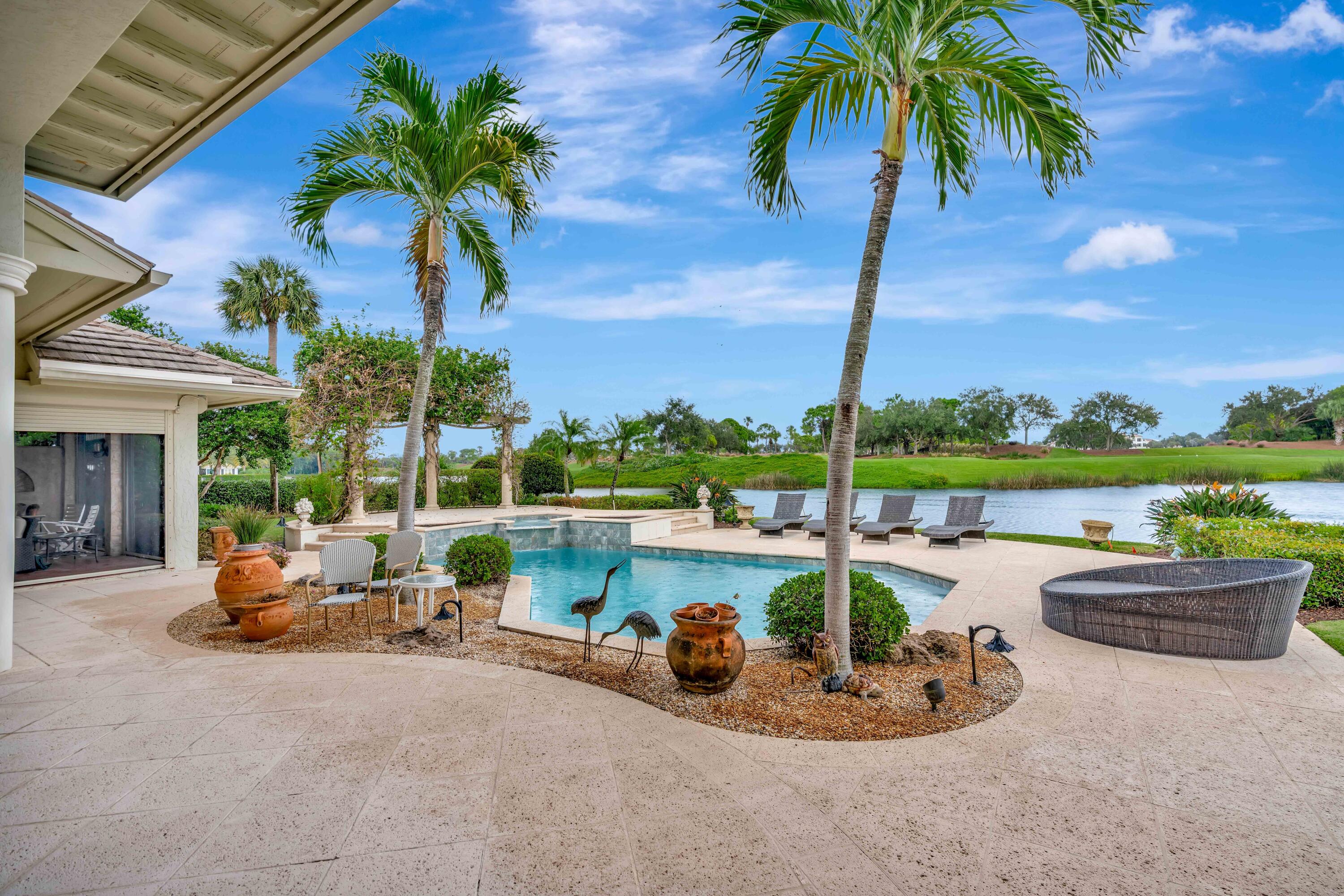 266 Locha Drive Jupiter, FL 33458 - Photo 41 of 60 a view of a swimming pool and a couches in a patio