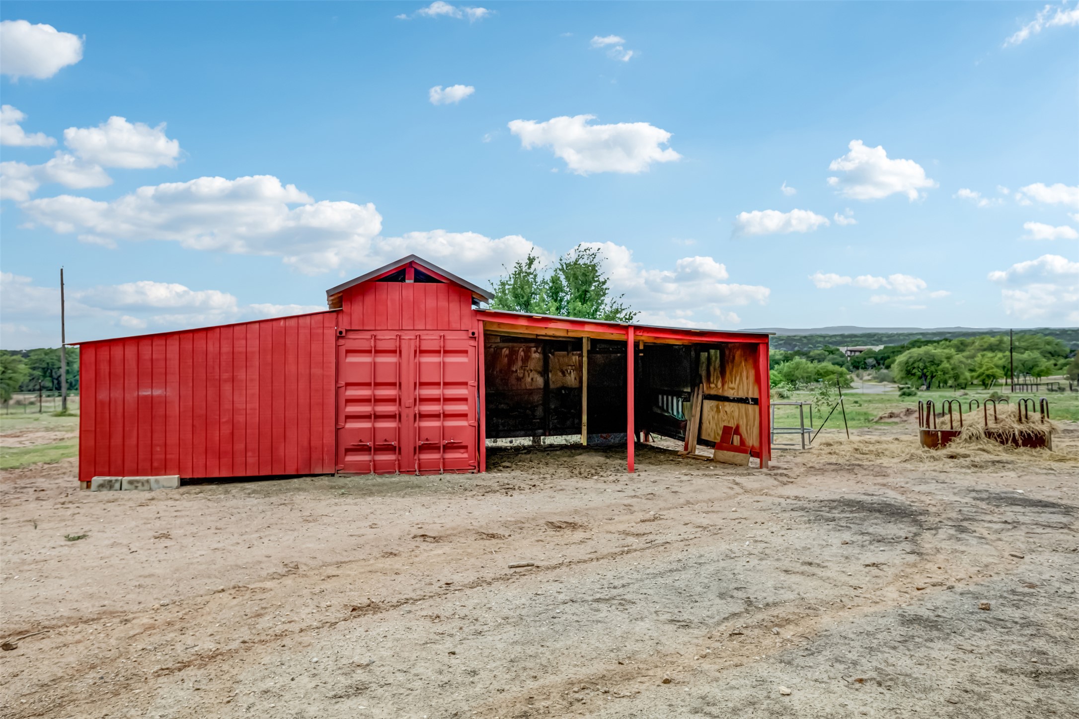 4909 Lookout Ridge Drive Marble Falls, TX 78654 - Photo 36 of 39 The property includes a red barn structure with an attached open-sided shelter