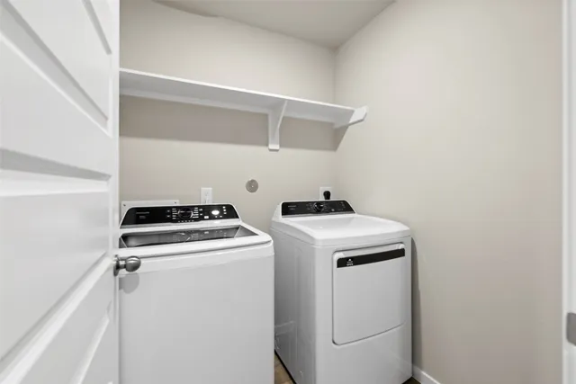 a view of washer and dryer with kitchen in the background