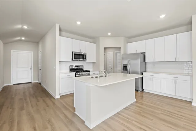 a kitchen with a sink a counter top space stainless steel appliances and cabinets