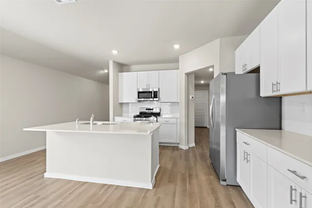 a kitchen with stainless steel appliances a refrigerator sink and wooden cabinets