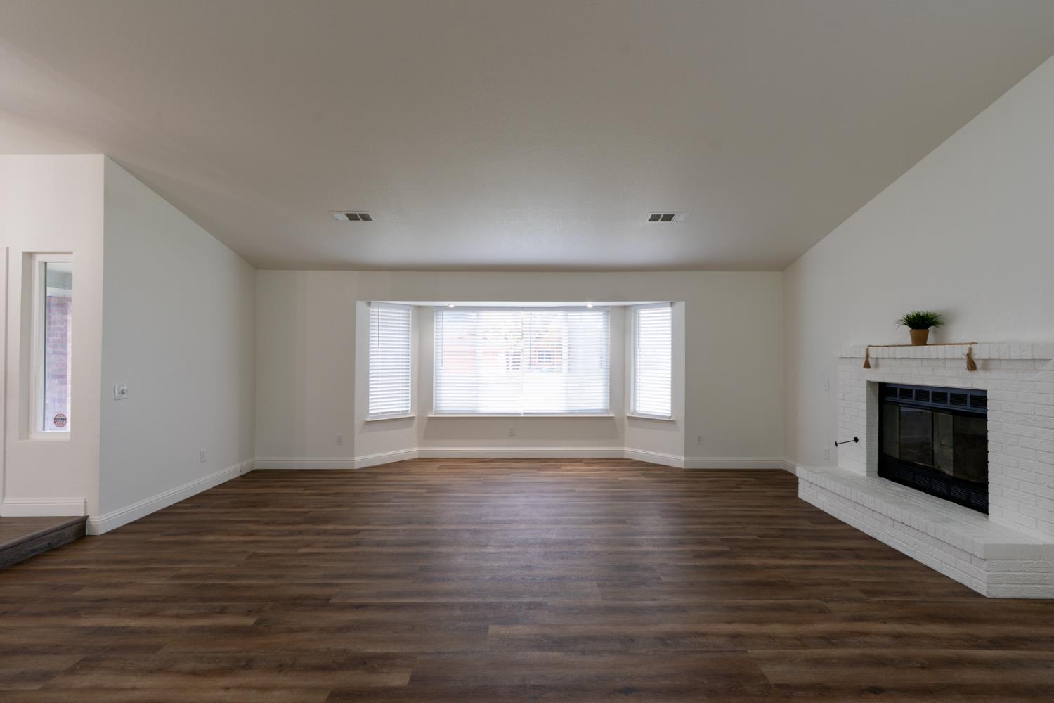 899 La Jolla Way Merced, CA 95348 - Photo 13 of 51 a view of empty room with wooden floor and fireplace