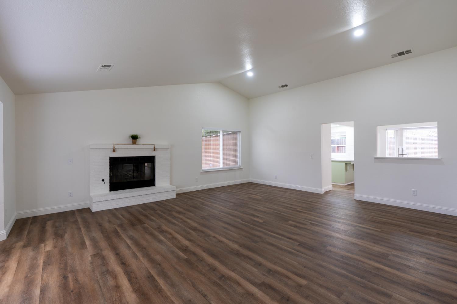 899 La Jolla Way Merced, CA 95348 - Photo 14 of 51 an empty room with wooden floor and fireplace