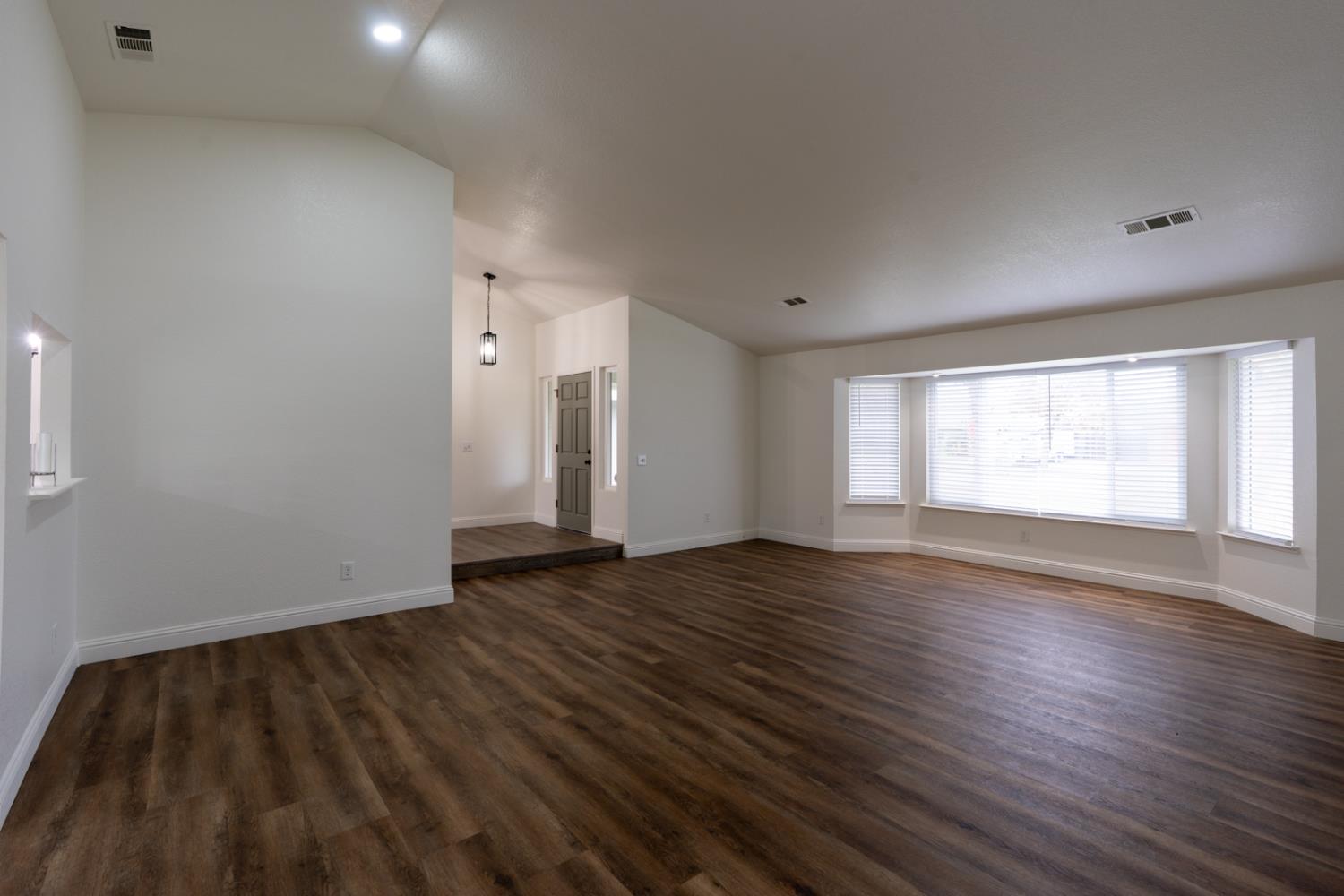 899 La Jolla Way Merced, CA 95348 - Photo 17 of 51 a view of an empty room with wooden floor and a window