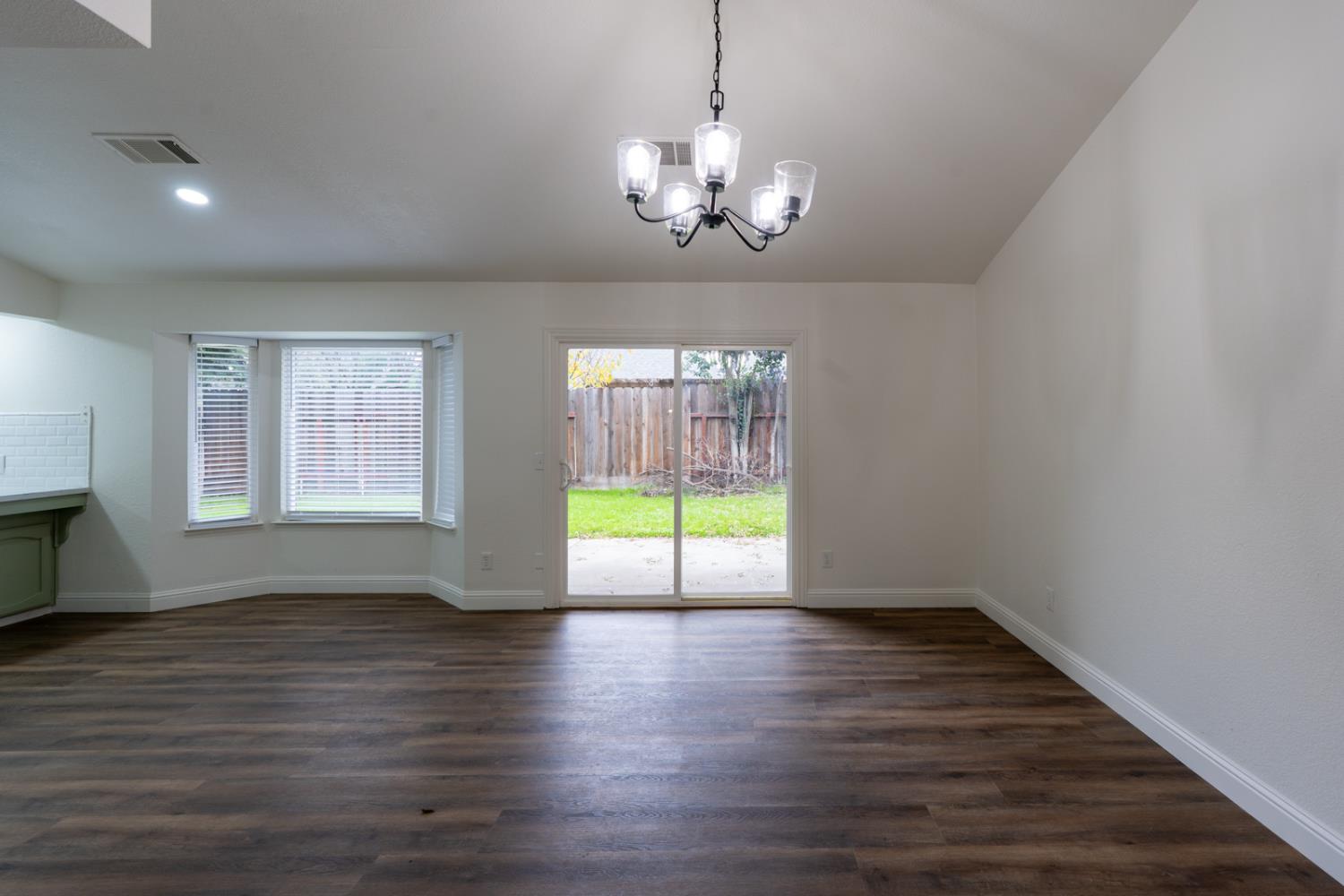 899 La Jolla Way Merced, CA 95348 - Photo 19 of 51 a view of an empty room with wooden floor and a window