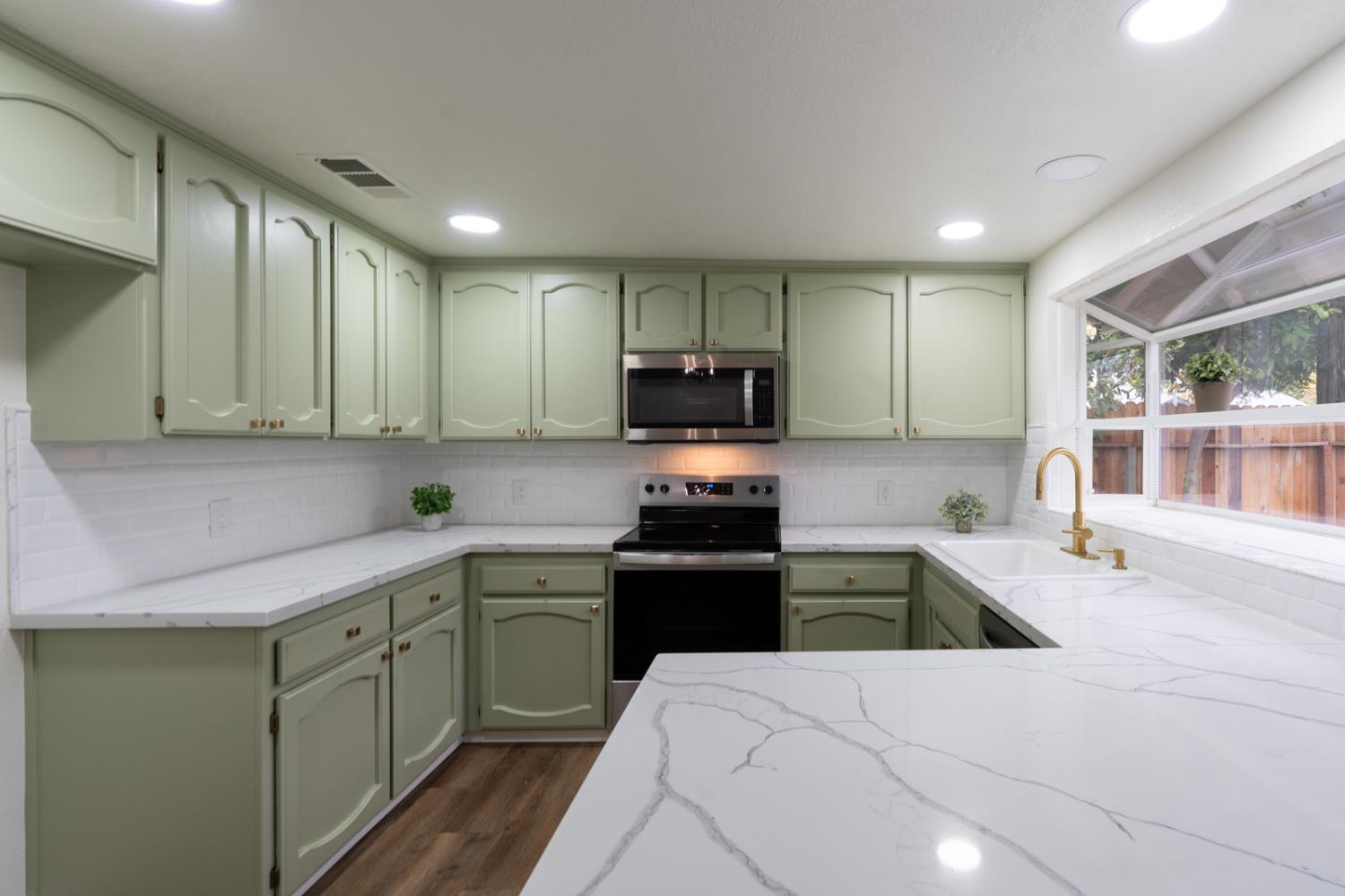 899 La Jolla Way Merced, CA 95348 - Photo 23 of 51 a kitchen with a sink cabinets and stainless steel appliances