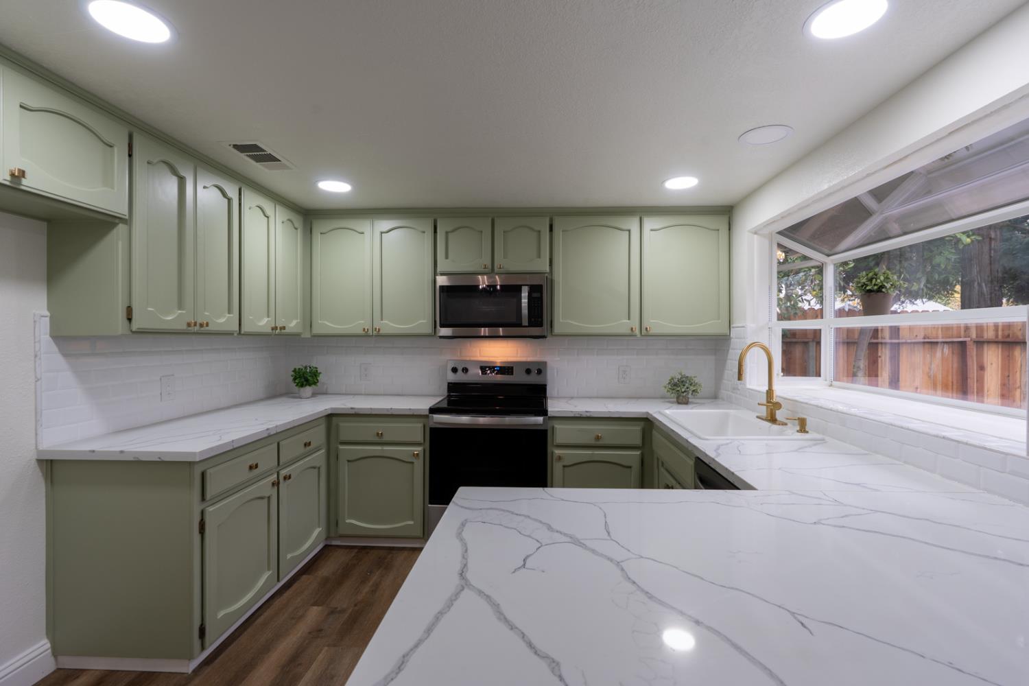 899 La Jolla Way Merced, CA 95348 - Photo 24 of 51 a kitchen with a sink stove top oven and cabinets