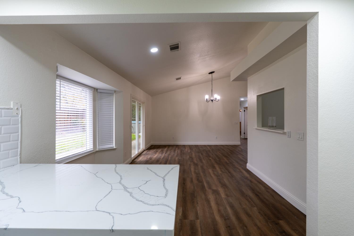 899 La Jolla Way Merced, CA 95348 - Photo 28 of 51 a view of a hallway to a bedroom with wooden floor and windows