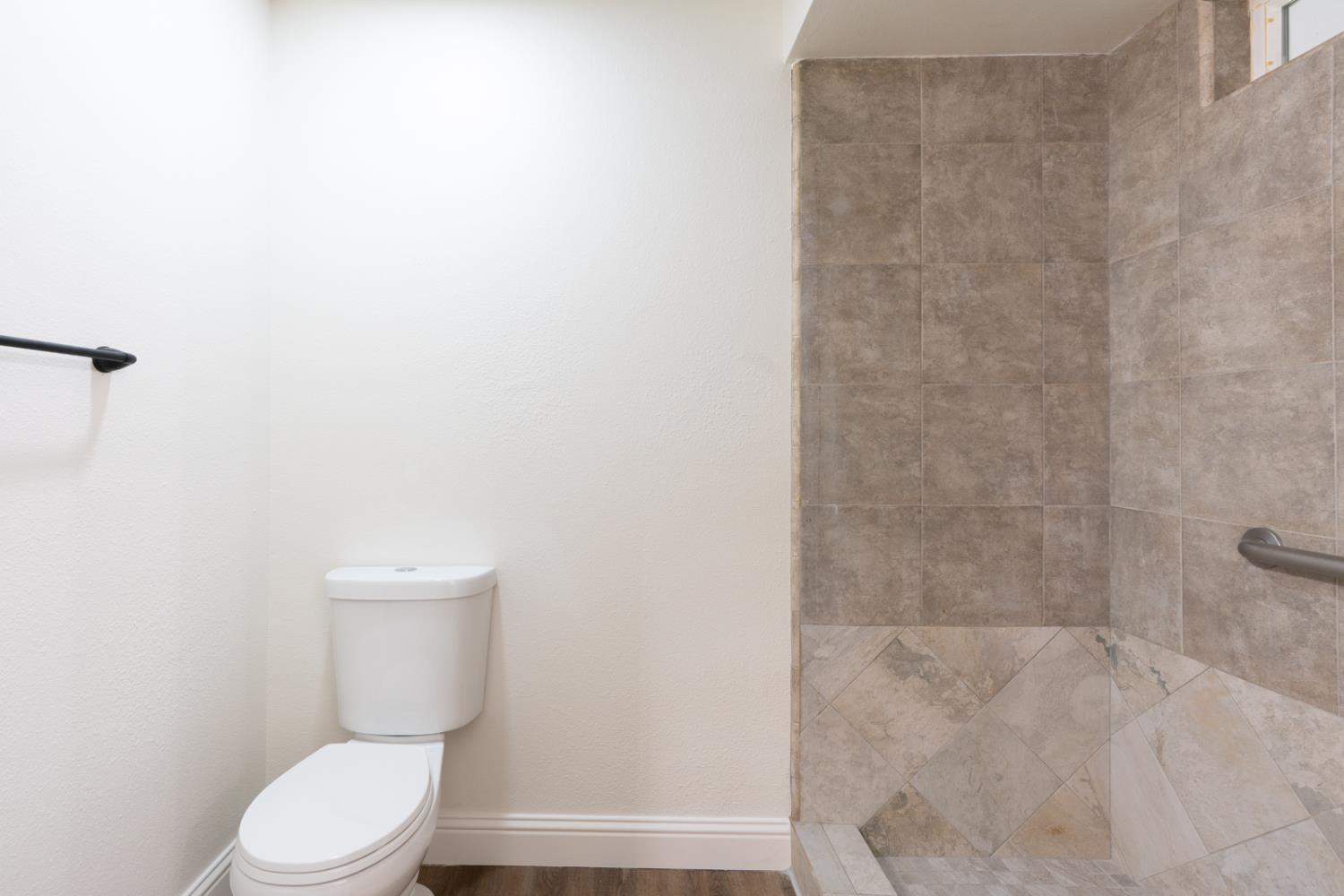 899 La Jolla Way Merced, CA 95348 - Photo 39 of 51 a white toilet sitting next to a shower