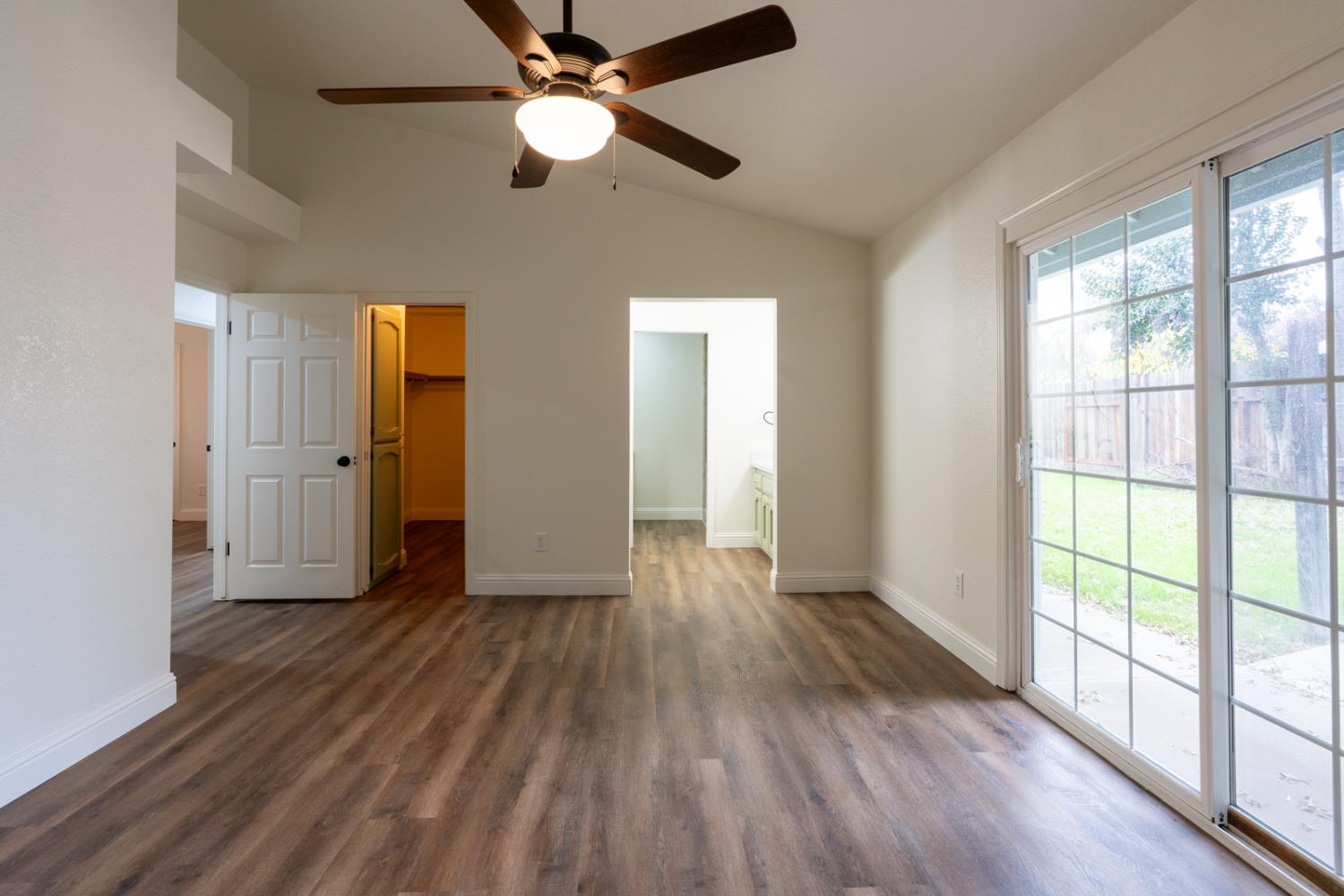 899 La Jolla Way Merced, CA 95348 - Photo 42 of 51 an empty room with wooden floor fan and windows