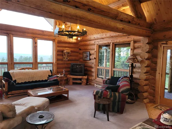 a living room with furniture a fireplace and a floor to ceiling window