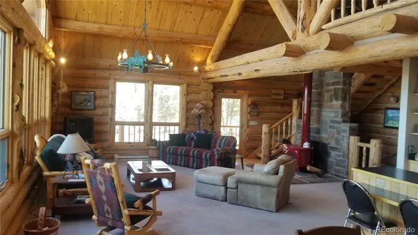 a living room with furniture a chandelier and a dining table