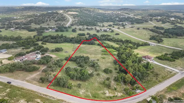 an aerial view of residential houses with outdoor space and trees