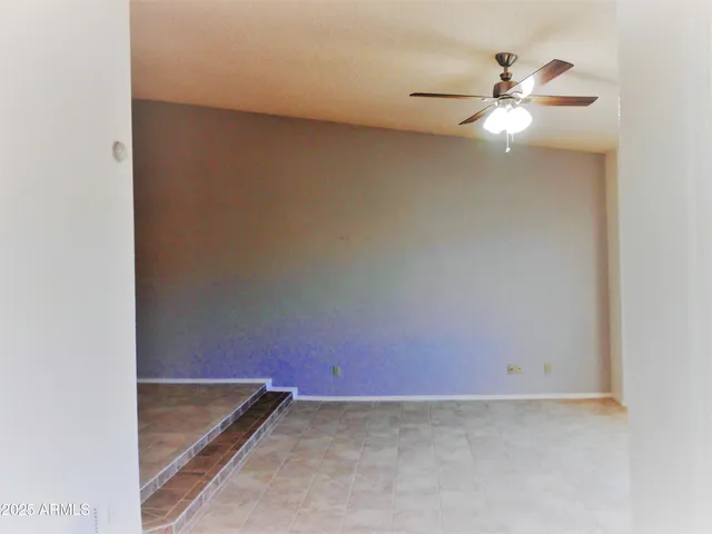 an empty room with a fan and a window