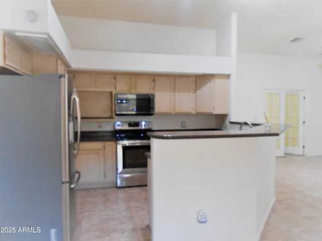 a kitchen with kitchen island a sink stainless steel appliances and cabinets