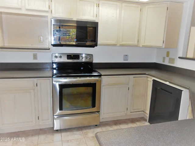 a kitchen with granite countertop white cabinets stainless steel appliances and sink