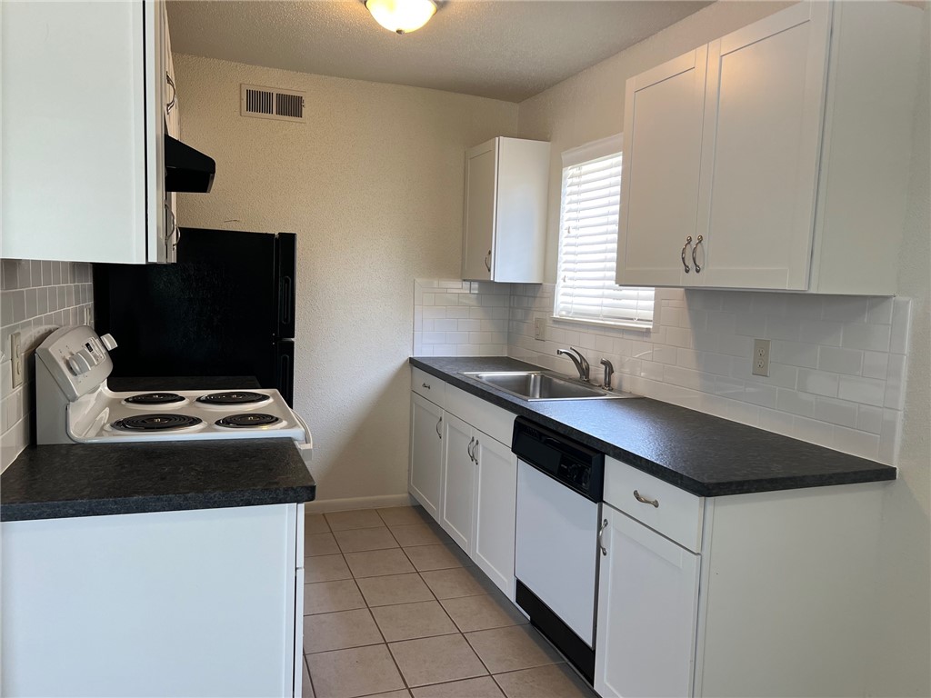 a kitchen with a sink and a stove top oven