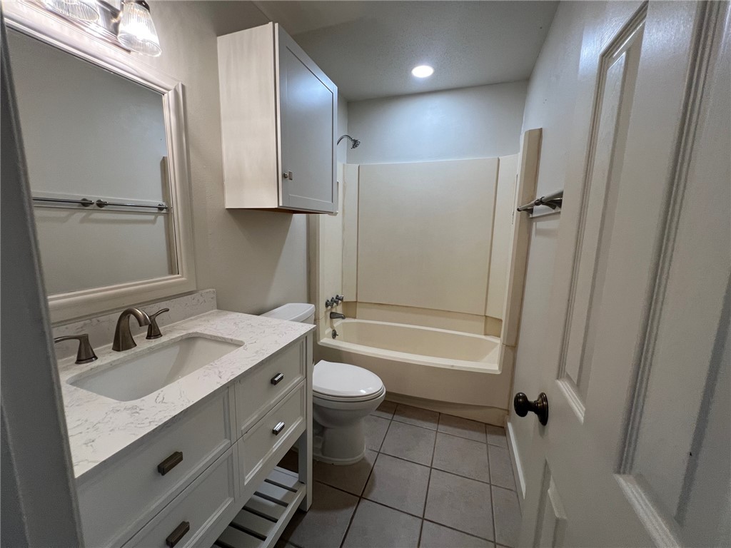 806 Natalie Street, Unit D Bryan, TX 77801 - Photo 6 of 7 a bathroom with a double vanity sink toilet mirror and bathtub