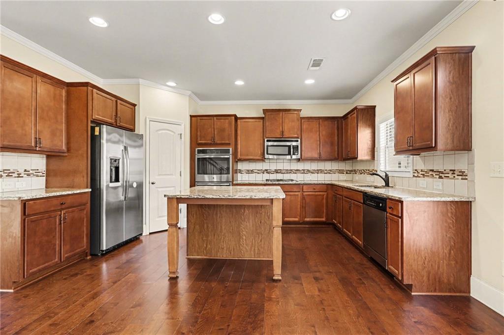 4208 Amberleaf Walk Lilburn, GA 30047 - Photo 13 of 33 a kitchen with a refrigerator stove top oven and cabinets