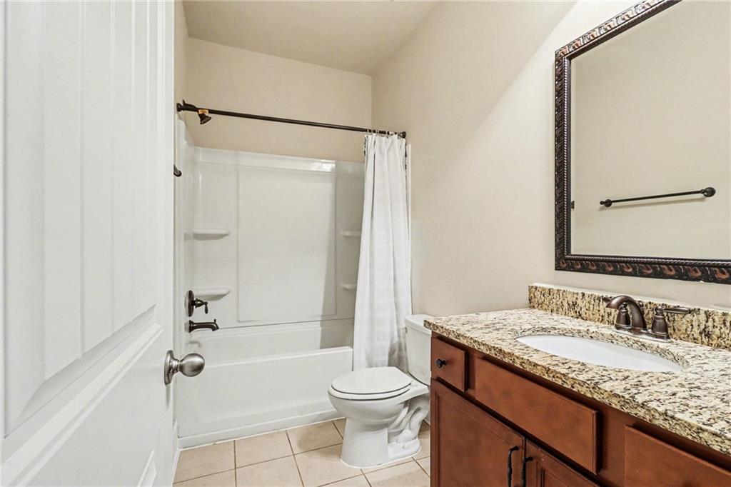 4208 Amberleaf Walk Lilburn, GA 30047 - Photo 16 of 33 a bathroom with a granite countertop sink toilet mirror and shower