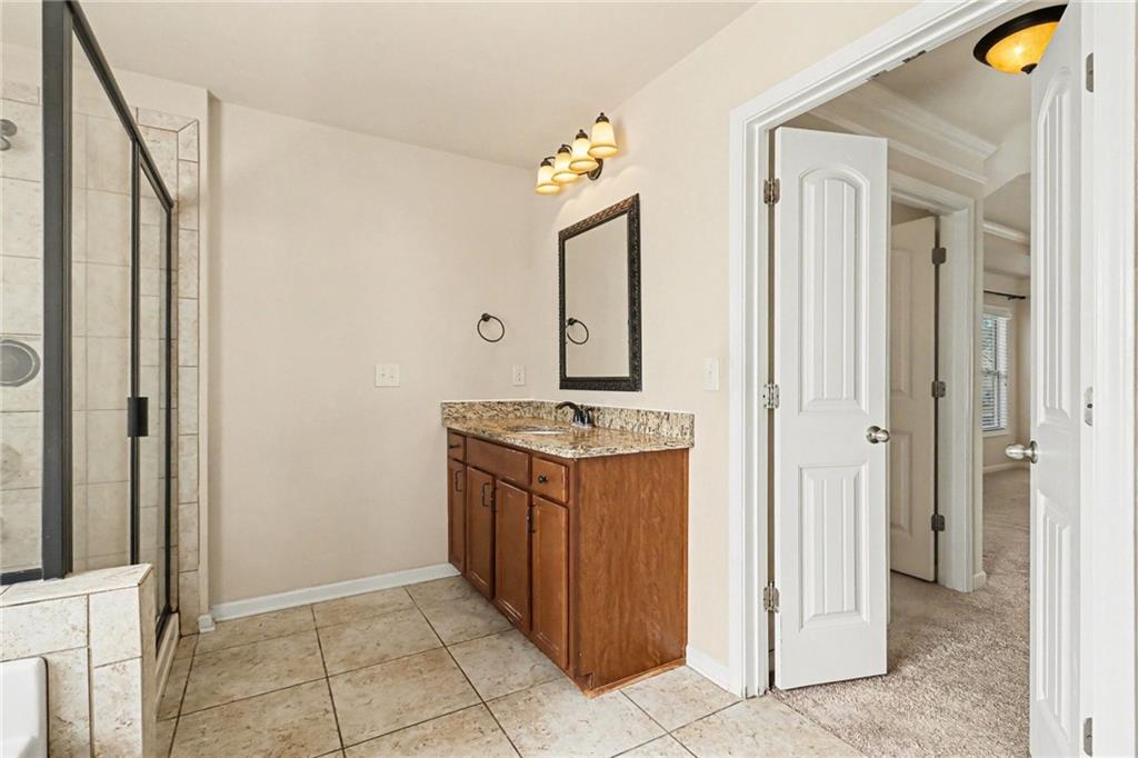 4208 Amberleaf Walk Lilburn, GA 30047 - Photo 29 of 33 a bathroom with a granite countertop sink and a mirror