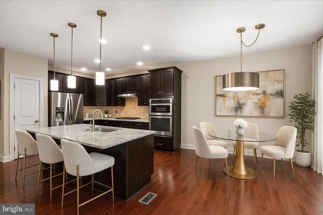 a dining room with furniture a chandelier and wooden floor