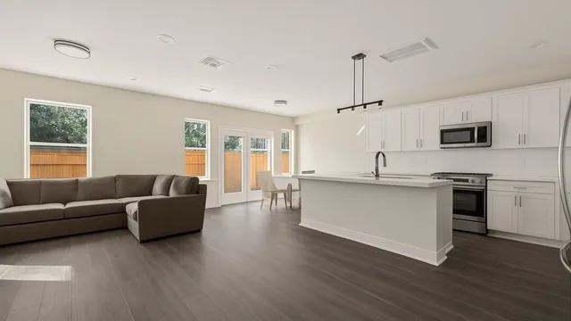 a living room with furniture and kitchen