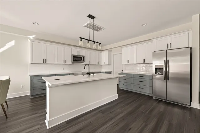 a kitchen with stainless steel appliances kitchen island hardwood floor sink and stove