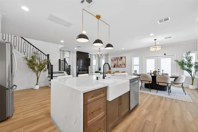 a large room with kitchen island a sink a counter space and living room view