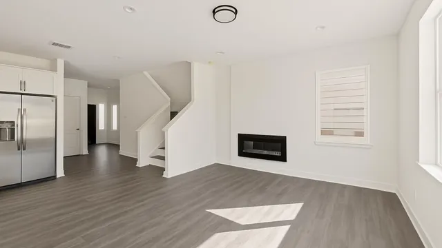 a view of a livingroom with wooden floor and a hallway