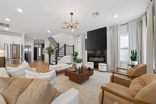 a living room with furniture a large window and a flat screen tv