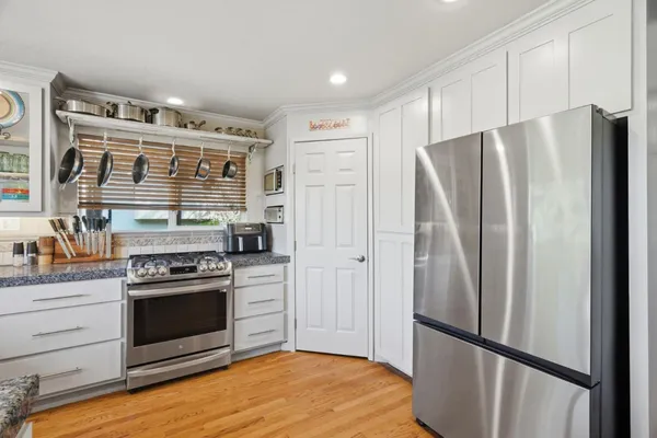 a kitchen with stainless steel appliances a refrigerator stove and wooden cabinets
