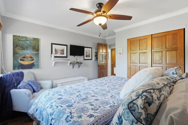 a bedroom with a bed and a flat tv screen on dresser
