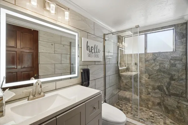 a bathroom with a sink toilet and shower