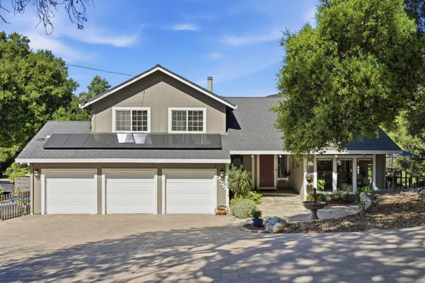 a view of a house with a yard and large tree