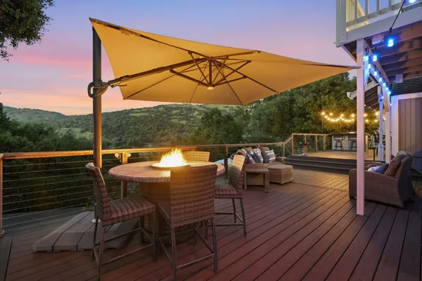 a view of deck with table and chairs under an umbrella