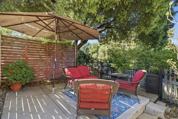 a patio with wooden floor a yard a table and chairs