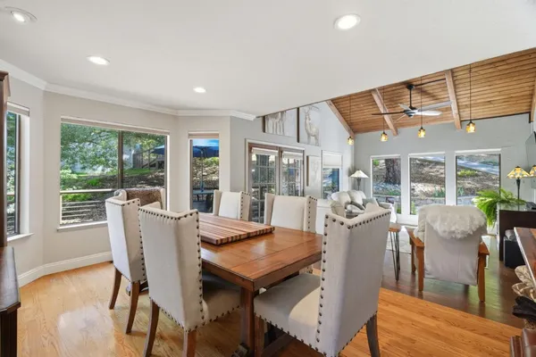 a view of a dining room with furniture large windows and wooden floor