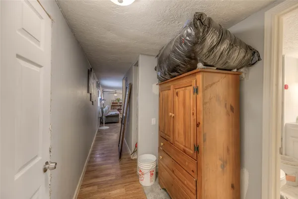 a walk in closet with wooden floor