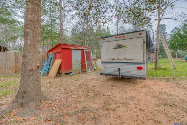 a view of backyard with wooden fence and a large tree